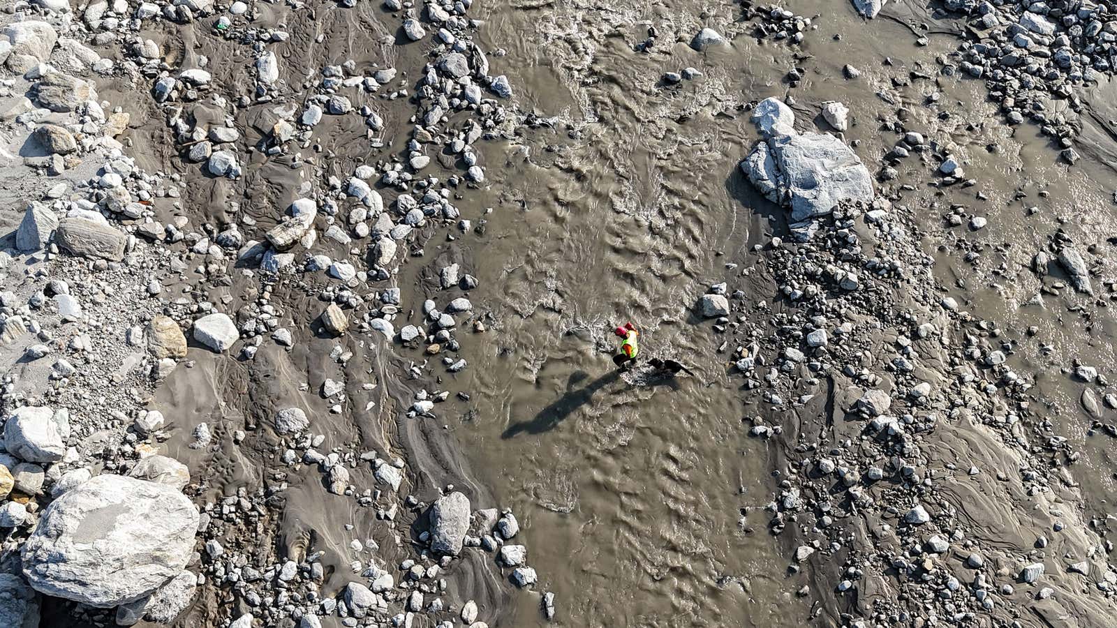 An aerial view shows a search and rescue team member, along with a sniffer dog, looking for victims following the Aug. 26 flash flood, on the bank of the Trishuli River in Nepal's Nuwakot district on Sept. 30, 2026.