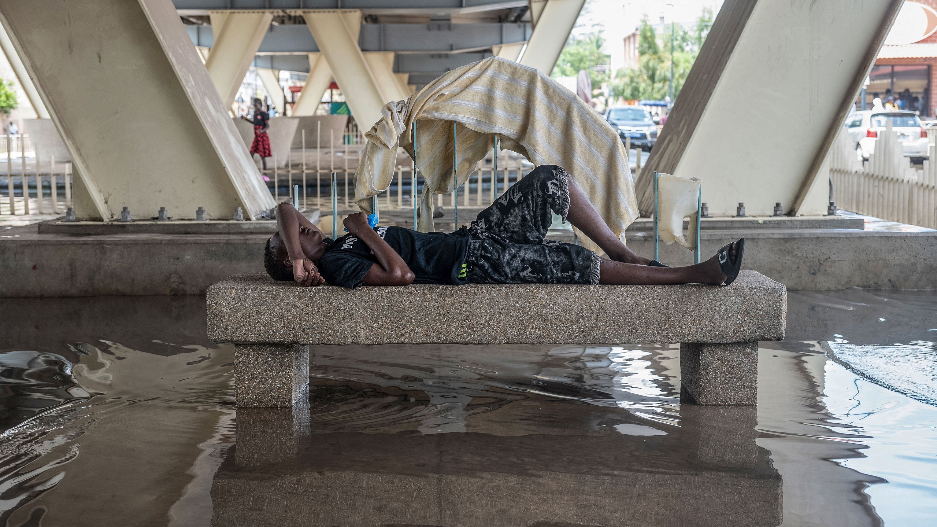 A man rests on a raised platform under a bridge in Dakar, on Oct. 5, 2026. Heavy rains flooded parts of Senegal on Sunday evening.