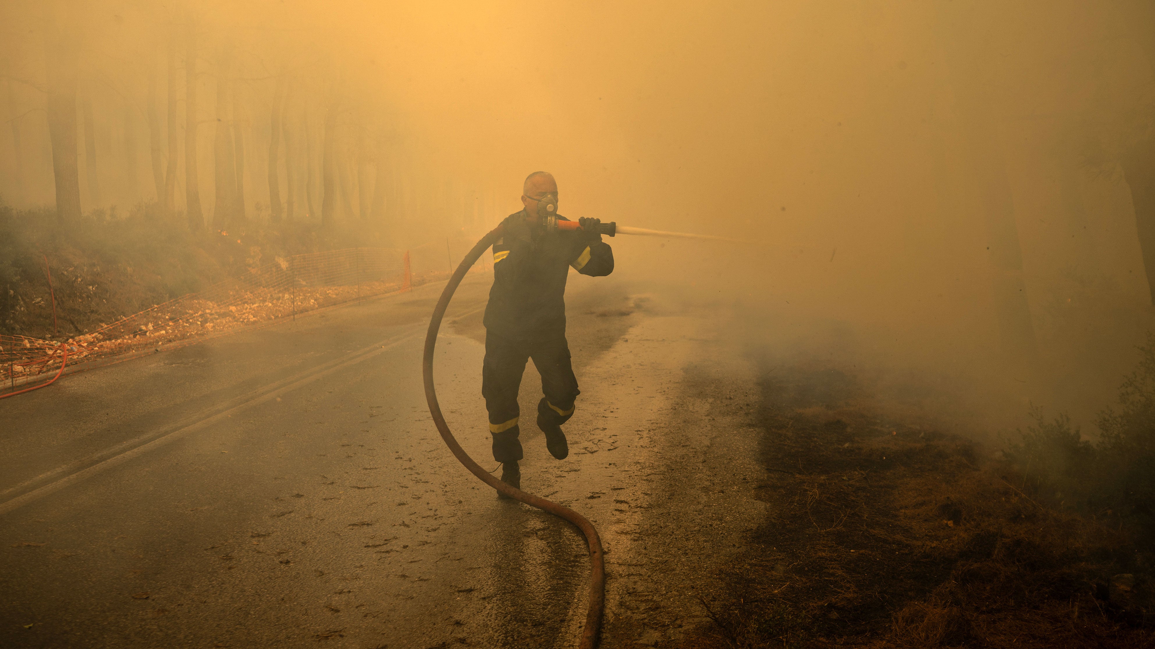 A Greek firefighter tries to extinguish a wildfire in the area of Porto Germeno, about 45 miles northwest of Athens in the region of Viotia, on Aug. 2, 2026.