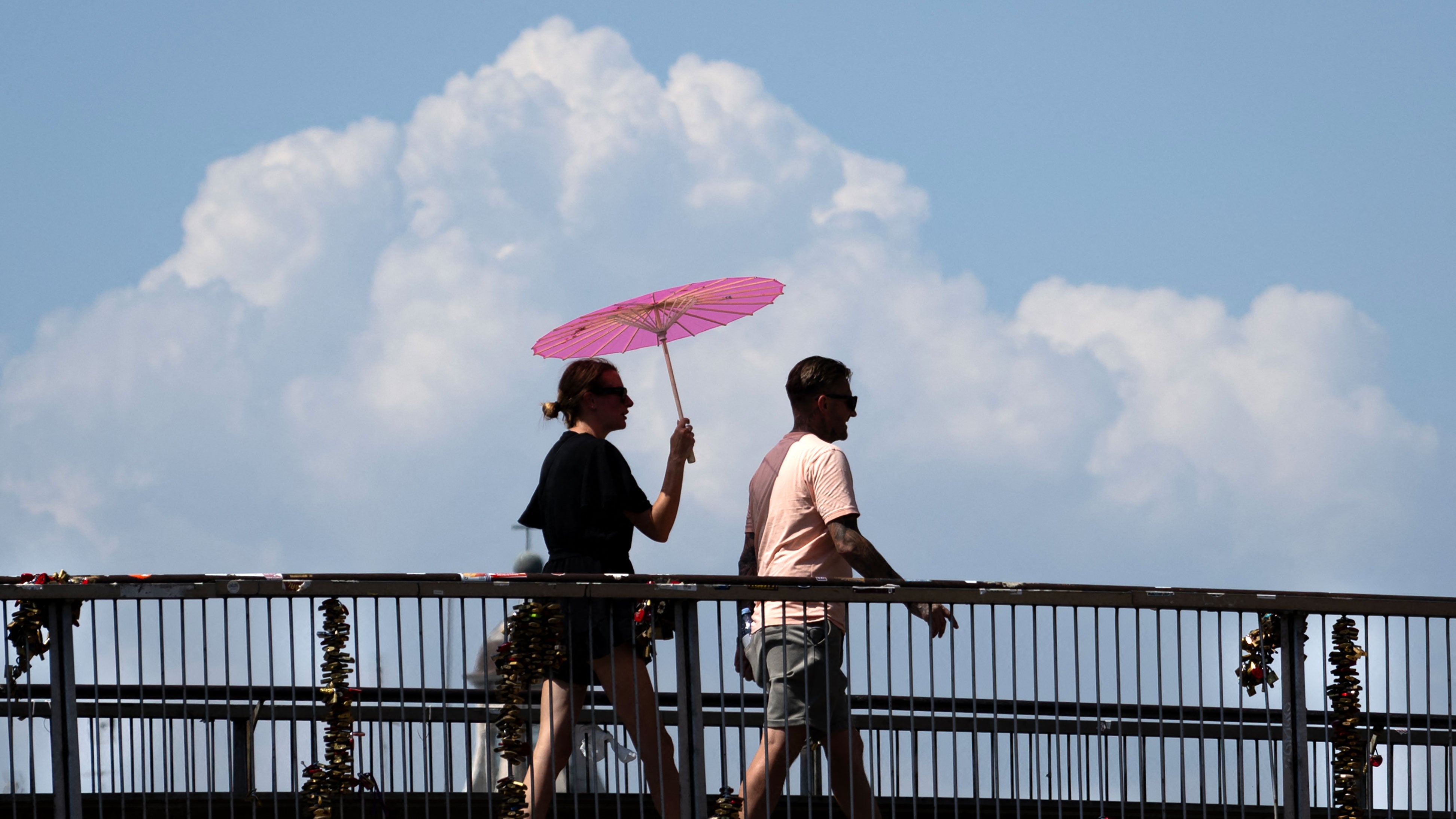 A woman walks holding an umbrella to shield herself from the sun during a heatwave in Rome at the Colosseum, on Aug. 6, 2026.
