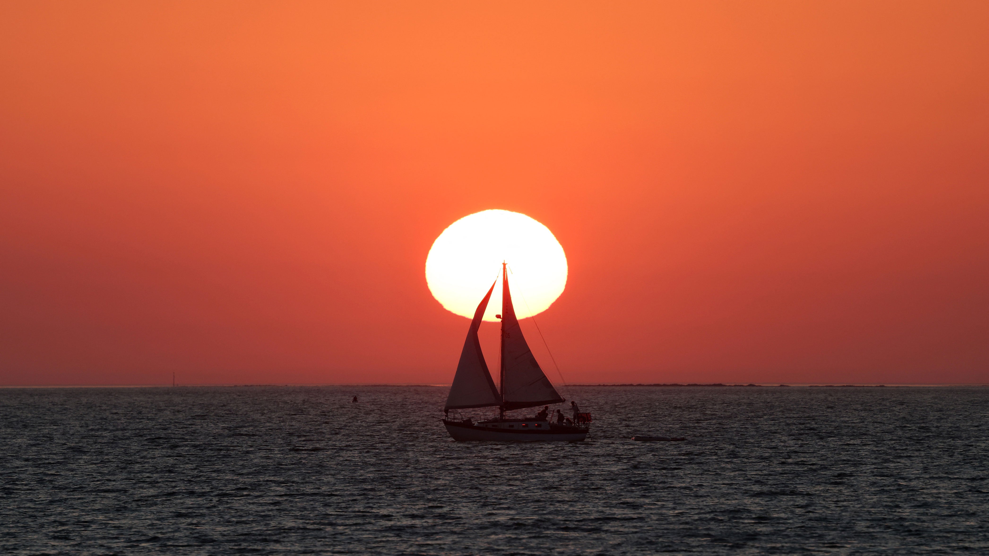 A sailboat cruises at sunset in Barbatre on the Noirmoutier island, west of France, on Wednesday, Aug. 12, 2026.