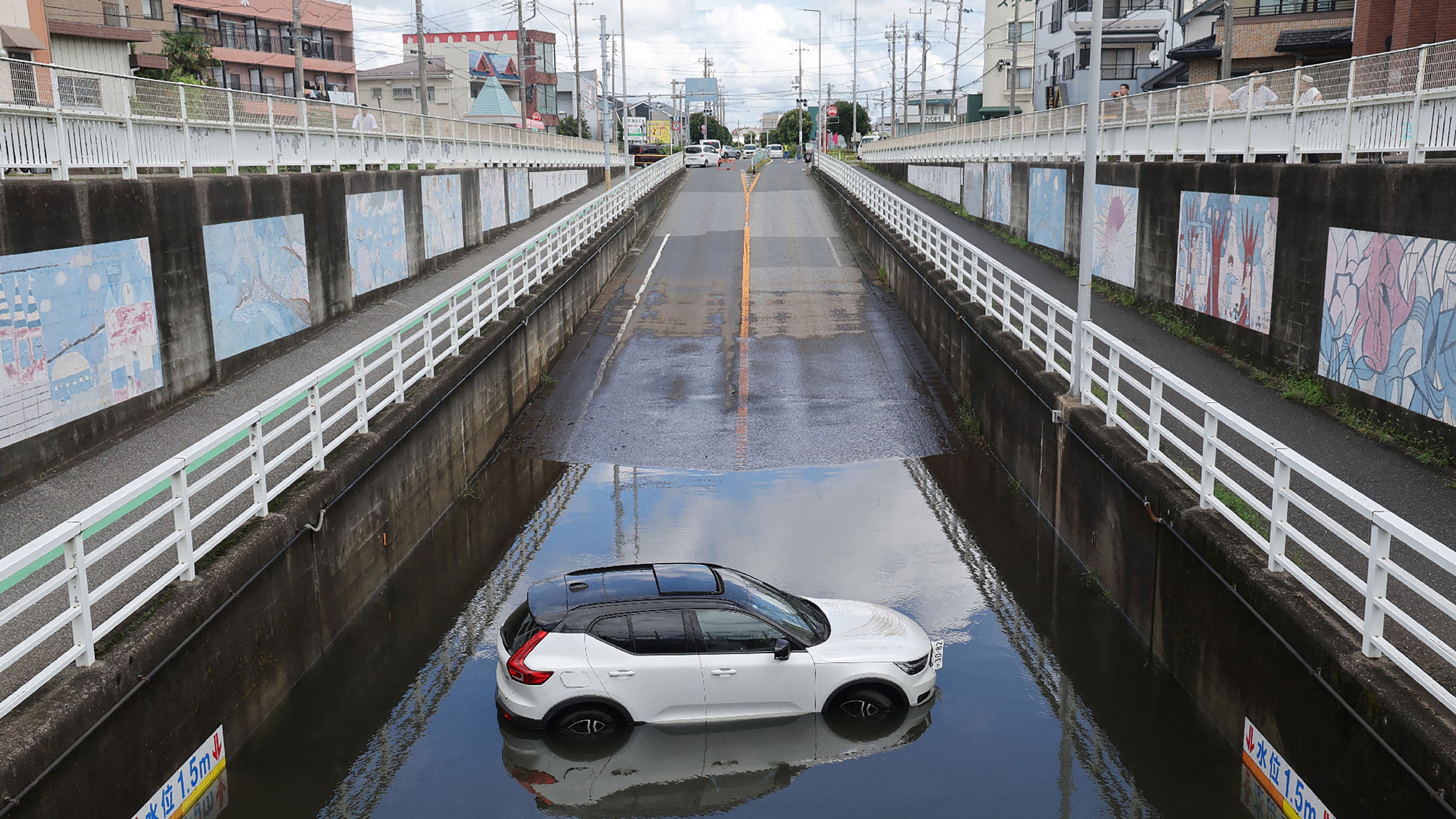 A car is submerged in water in an underpass in Kamagaya city, Chiba Prefecture, Japan on Friday, Aug. 14, 2026. At least four people died in eastern Japan after "unprecedented" heavy rain that left thousands stranded at Narita airport overnight and snarled up roads and rail services.