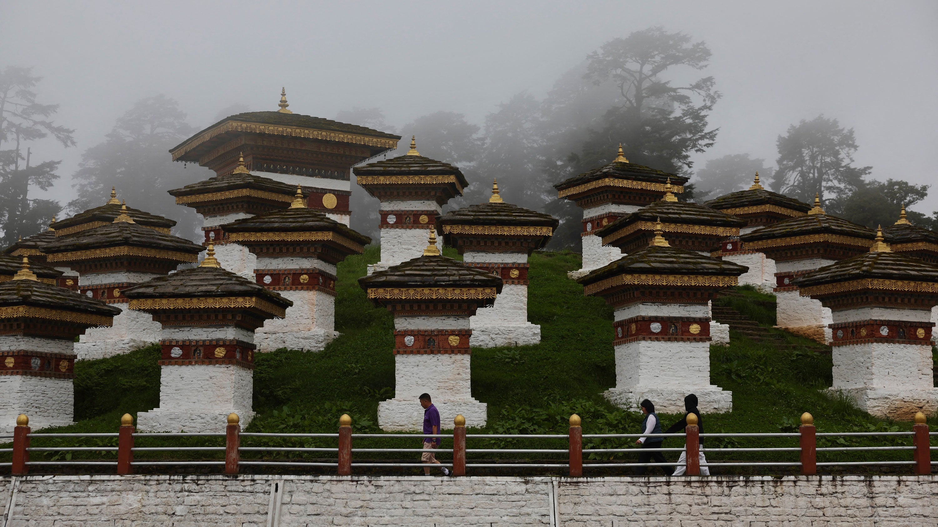 On a foggy day, people visit the Druk Wangyal Chortens, a sacred complex with 108 memorial chortens or stupas at Dochula Pass in South Asia, on Saturday, Aug. 29, 2026.