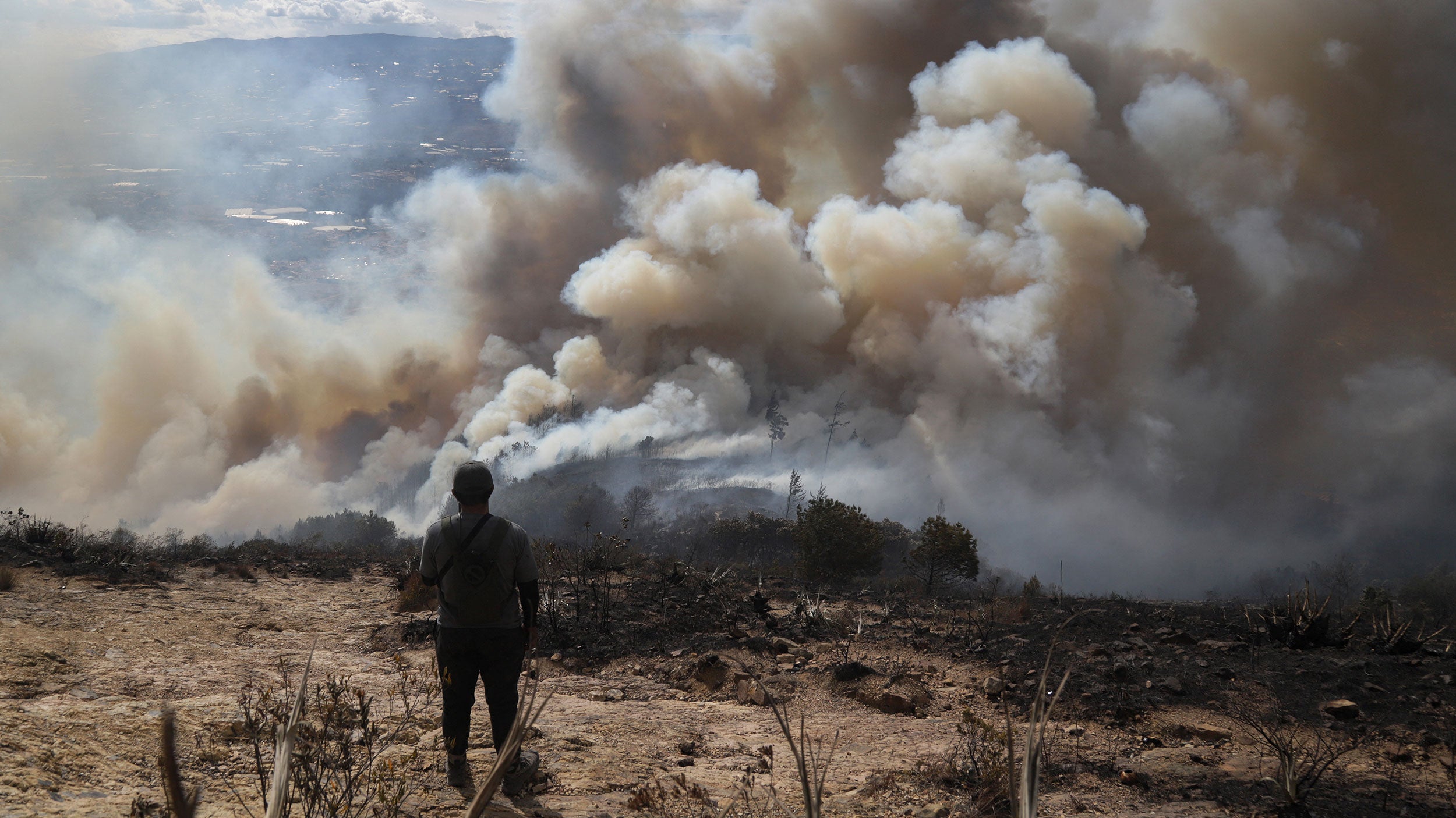 A volunteer looks on as a forest fire burns on San Marcos Hill in the municipality of Villa de Leyva, Boyaca department, Colombia, on Sept. 20, 2026.