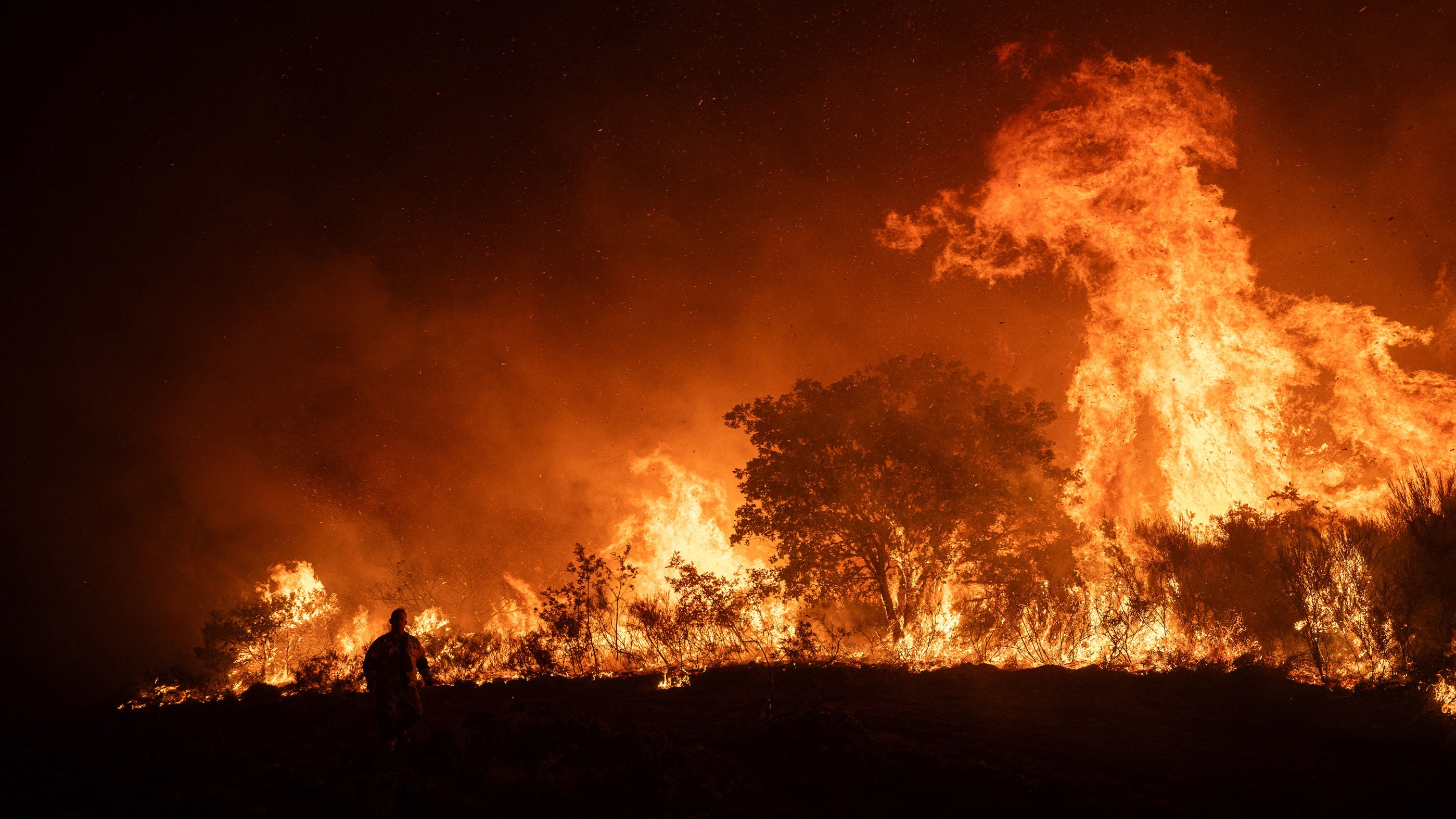 Spain's firefighters attempt to extinguish a forest fire near the hamlet of Baltar, close to the town of Xinzo de Limia in northwest Spain, on Sept. 24, 2026. The blaze has burned more than 345 acres. Eight helicopters and nine aircraft were deployed alongside ground crews.