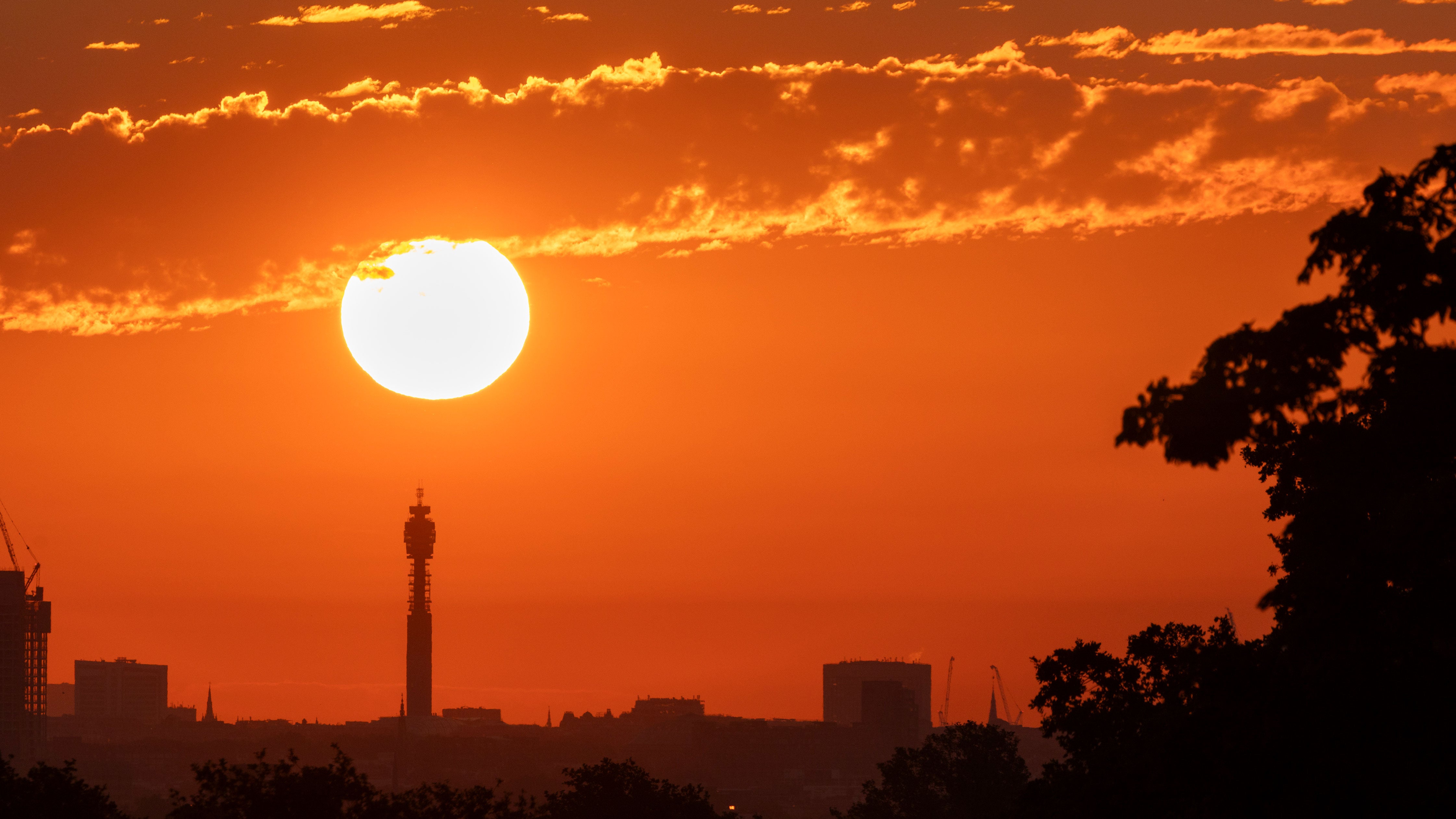 The sun rises over central London viewed from Richmond Park on June 19, 2026, in London, England. Temperatures were set to rise today with a heatwave forecast to develop over the weekend, prompting yellow weather warnings and advice to stay hydrated.
